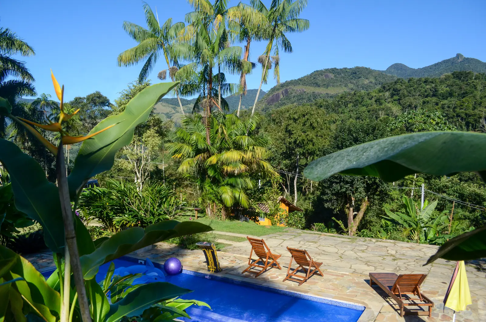 Piscina com espreguiçadeiras e vista para a Serra da Bocaina