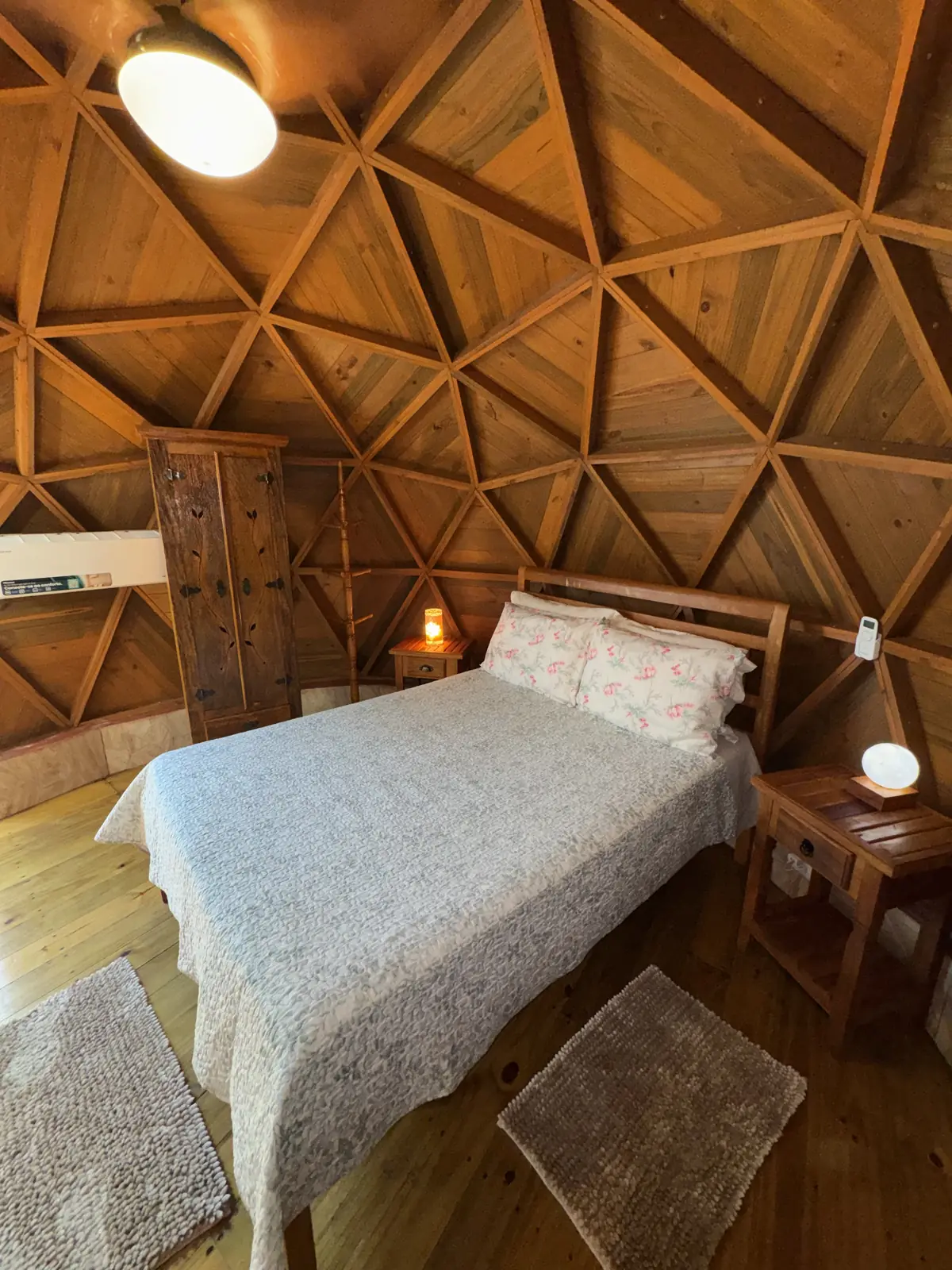 Interior do Domo João de Barro, com cama de casal sob a estrutura geodésica